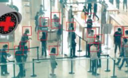 a security camera point of view of individuals waiting in line at airport security. Their faces have been marked by a red square 